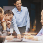 smiling female boss talking to business team