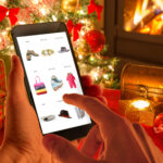 Christmas online shopping with phone. Christmas tree, gifts, lights and decorations.