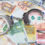 handcuffs on the background of banknotes